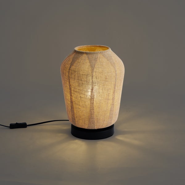 Tischleuchte mit naturfarbenem Stoffschirm in Vasenform, schwarzer Standfuß und Netzkabel mit Schalter.