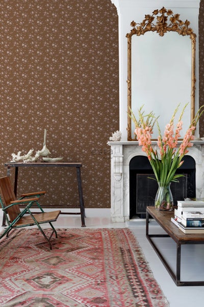 Wohnzimmer mit brauner Blumentapete, Spiegel, Kamin und Teppich