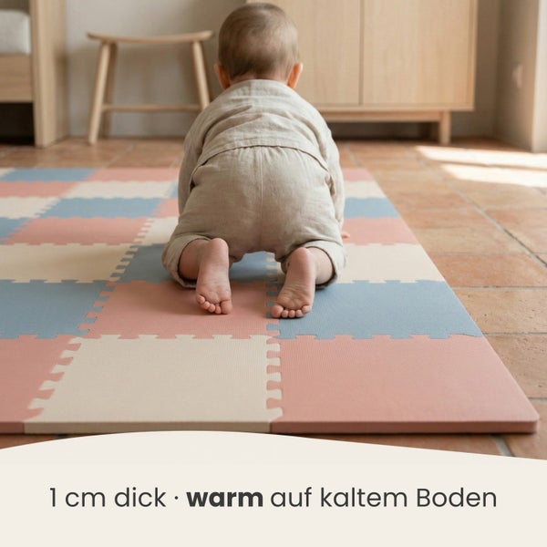 Baby krabbelt auf einer 1 Zentimeter dicken Puzzlematte aus Schaumstoff auf einem Fliesenboden.