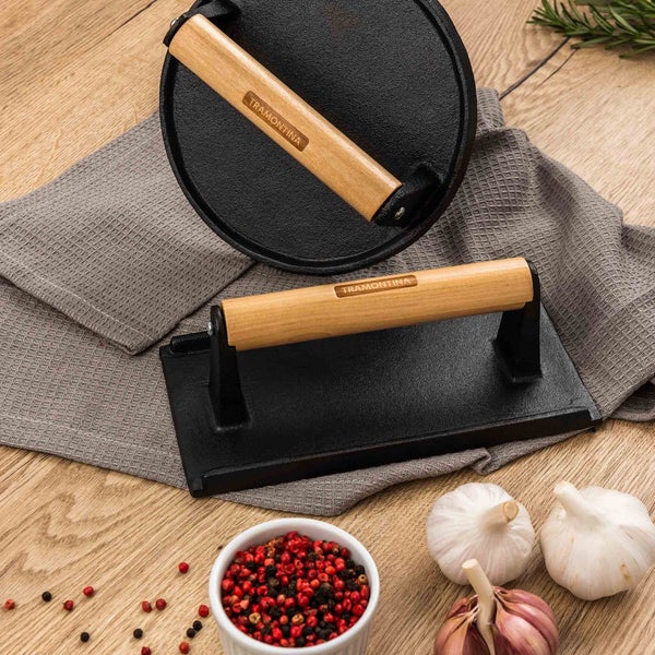 Zwei Grillpressen der Marke Tramontina mit Holzgriff auf einem Küchentuch.