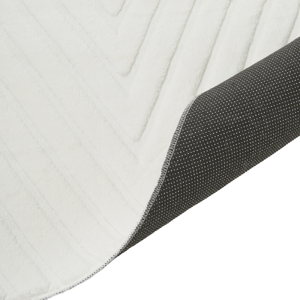 Ein kurzfloriger Teppich mit geometrischem Reliefmuster und rutschfester Unterseite mit Noppen.