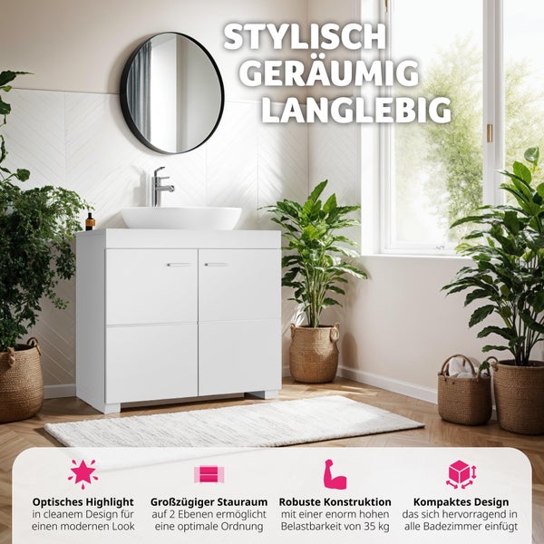 Moderner weißer Badunterschrank mit Aufsatzwaschbecken, runder Spiegel und Zimmerpflanzen in einem hellen Badezimmer mit Fliesen in Fischgrätoptik.
