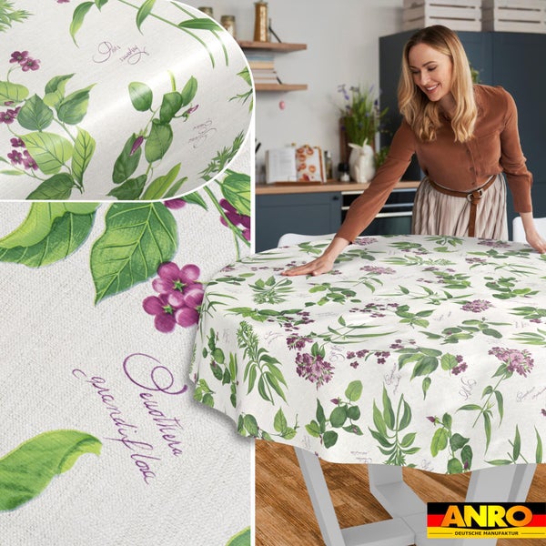 Runde Tischdecke mit botanischem Muster aus grünen Blättern und violetten Blüten in einer modernen Küche. ANRO Logo.