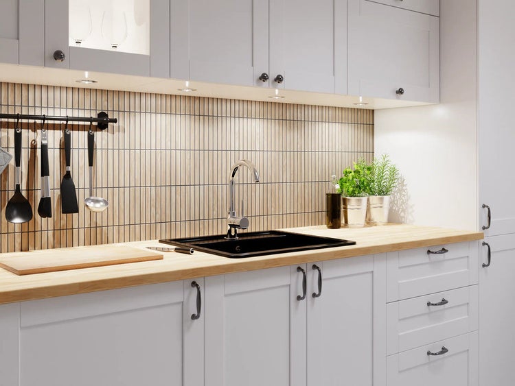 Helle Küche mit Spüle, Armatur, Arbeitsplatte und Küchenutensilien.