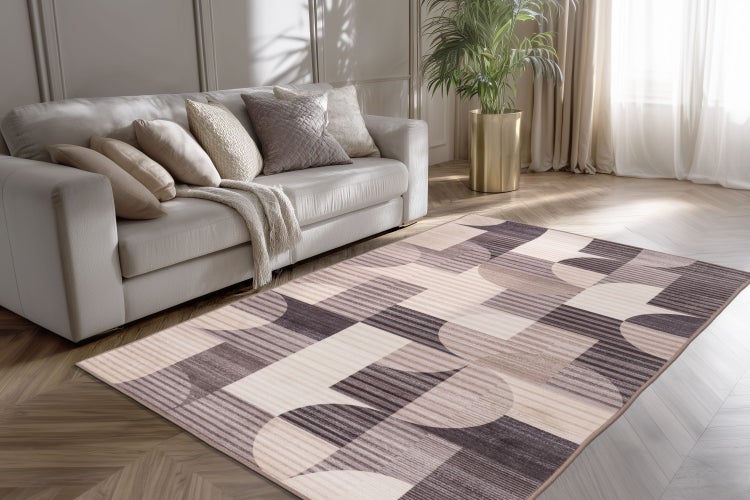 Moderner Wohnzimmerteppich mit geometrischem Muster vor einem Sofa in einem hellen, elegant eingerichteten Wohnbereich mit Fischgrätparkettboden.