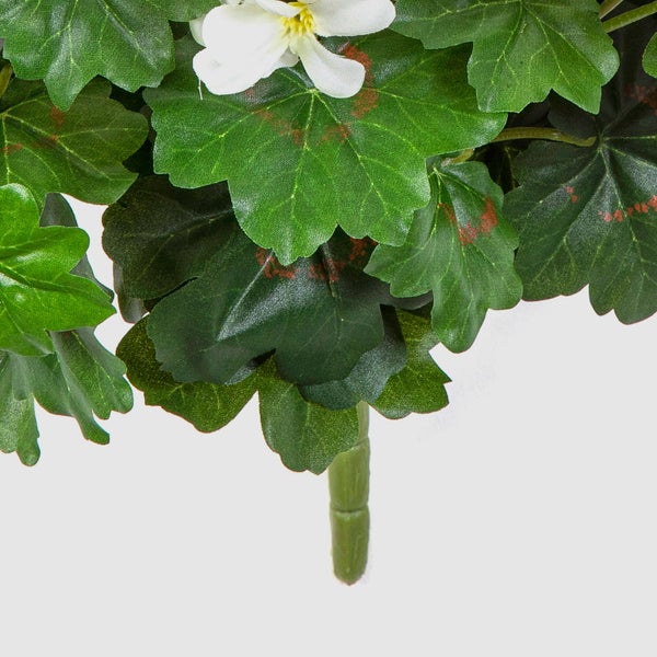 Künstliche Geranie mit grünen Blättern und einer weißen Blüte am Stiel.