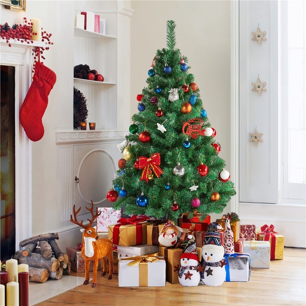 Dekorierter Weihnachtsbaum mit Geschenken in einem Wohnzimmer.