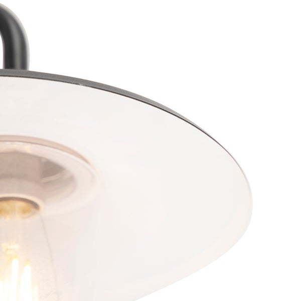 Detailansicht einer Außenwandleuchte mit klarem Glasschirm, Metallarm und sichtbarem Leuchtmittel.
