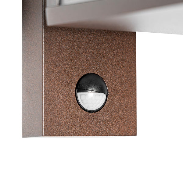 Nahaufnahme eines integrierten Bewegungsmelders an einer Außenwandleuchte mit strukturierter Oberfläche.