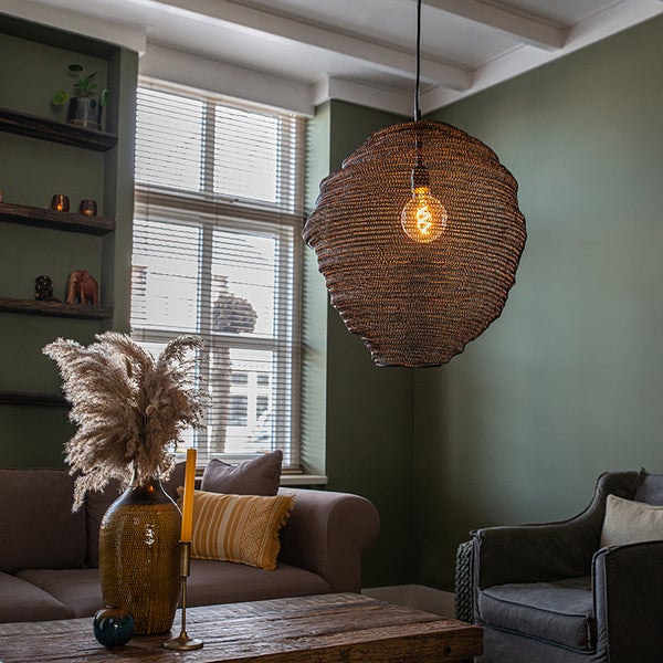 Wohnzimmer mit Couch, Sessel, Holztisch, Regalen und hängender Lampe