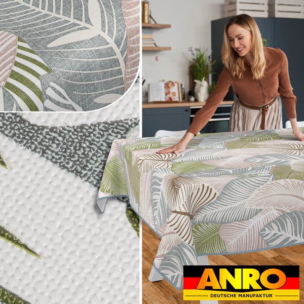 Frau deckt Tisch mit ANRO Tischdecke mit Blattmuster in Küche.