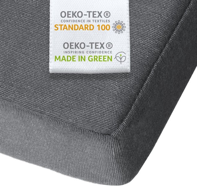 OEKO-TEX Standard 100 und Made in Green Siegel auf einem grauen Polster für schadstoffgeprüfte Textilien und nachhaltige Produktion.