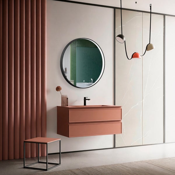 Modernes Badezimmer mit hängendem Waschtisch, rundem Spiegel, Armatur und moderner Hängeleuchte vor einer strukturierten Wand.