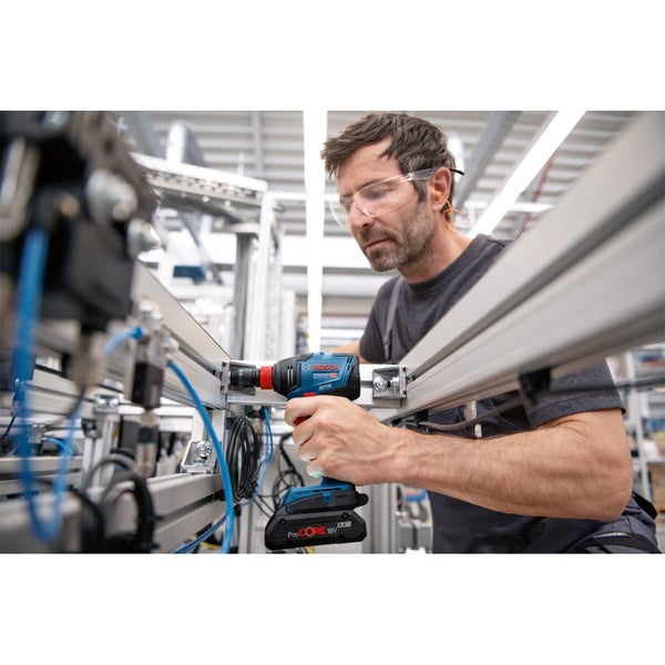 Ein Mann arbeitet mit einem Akku-Schlagschrauber an einer Metallkonstruktion.