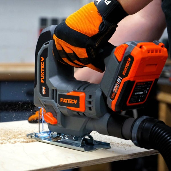 Akkustichsäge beim Sägen von Holz mit einer Person, die Handschuhe trägt, und einem Staubsaugeranschluss.