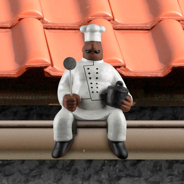 Dachfigur Koch sitzend auf einer Dachrinne, hält einen Topf und ein Küchenutensil.
