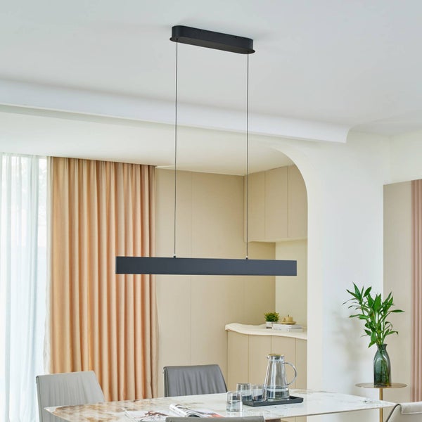 Schwarze, lineare Pendelleuchte in einem hellen, modern eingerichteten Esszimmer über einem Marmortisch mit Stühlen und Vorhängen.