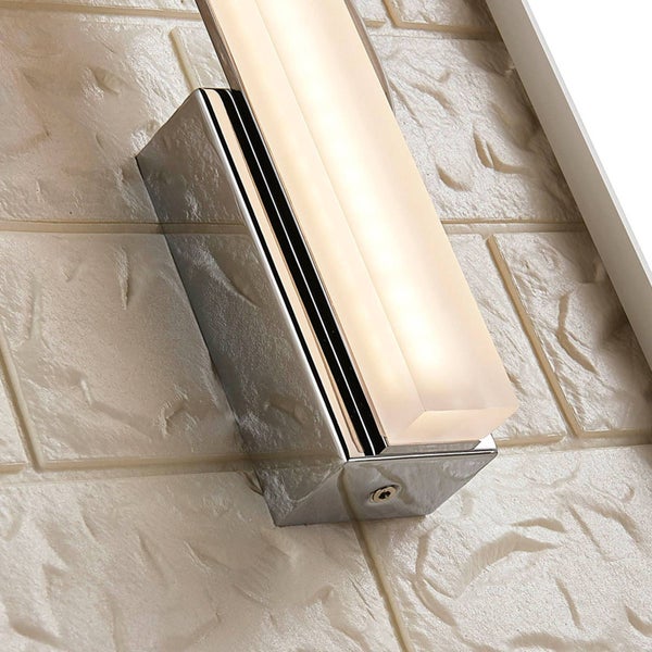 Moderne LED Wandleuchte mit verchromtem Metallsockel und rechteckigem mattiertem Glasdiffusor montiert an einer strukturierten Wand.