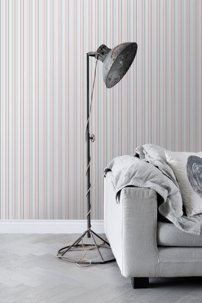 Wohnraum mit gestreifter Tapete, Stehlampe und Sofa