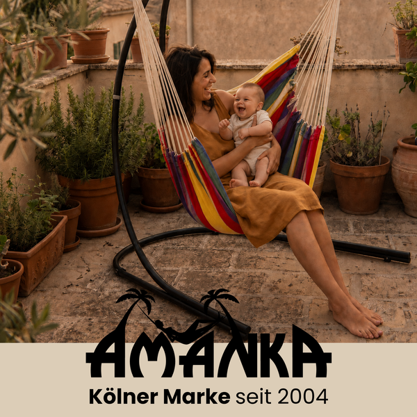 Frau mit Baby in einem bunten Hängesessel auf einer Terrasse mit Topfpflanzen und Amanka Logo.
