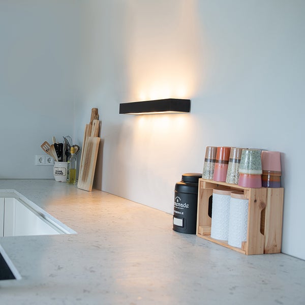 Moderne Küche mit Arbeitsplatte und Wandleuchte zur Beleuchtung