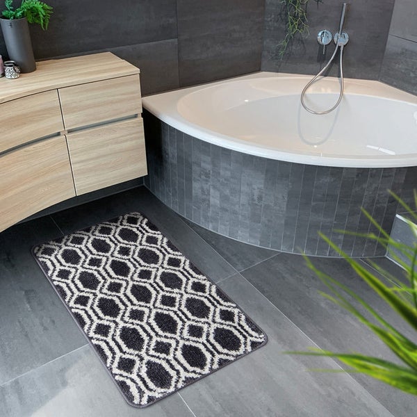 Modernes Badezimmer mit Waschtisch, Eckbadewanne und einem Badteppich mit geometrischem Muster