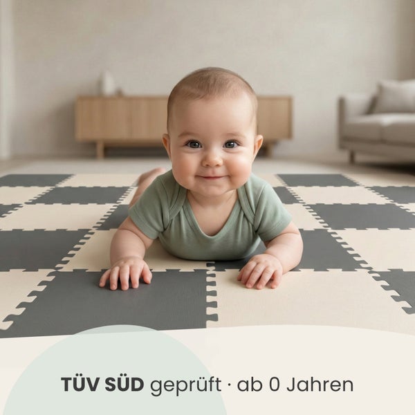Ein Baby liegt auf einer Puzzlematte aus Schaumstoff in einem hellen Wohnzimmer. Die Matte ist TÜV SÜD geprüft und ab 0 Jahren geeignet.