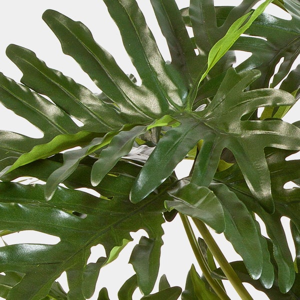 Künstliche Pflanze Philodendron mit großen, glänzenden und tief gelappten Blättern.