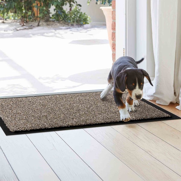 Fußmatte mit Hund vor einer Terrassentür.