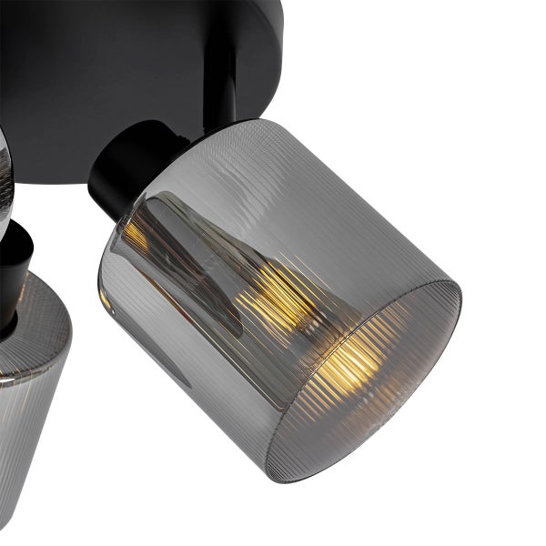 Schwarze Deckenleuchte mit geriffeltem Schirm aus Rauchglas und LED-Filament-Leuchtmittel mit warmweißem Licht.