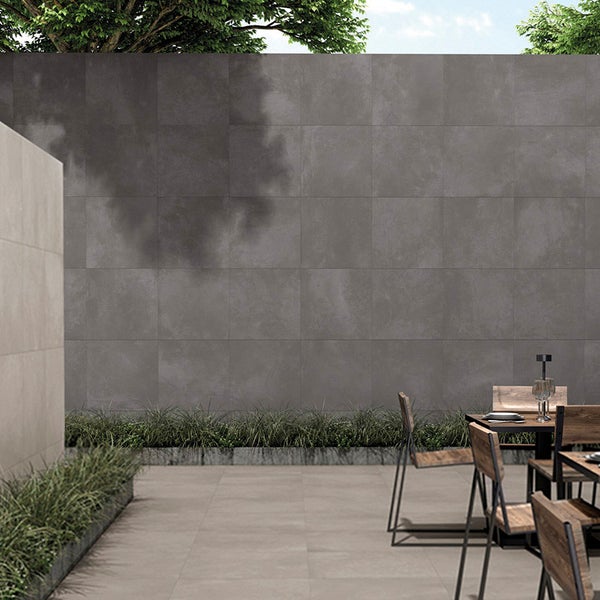 Moderne Terrasse mit grossformatigen quadratischen Fliesen in Betonoptik, kombiniert mit Sitzgruppe im Freien und integrierten Pflanzbeeten.