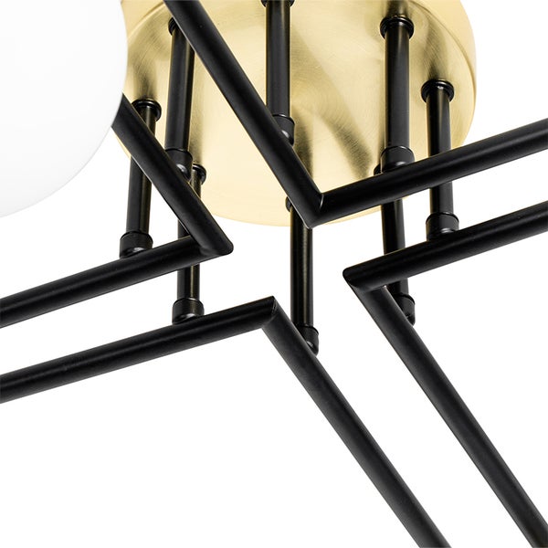 Detailaufnahme einer Deckenleuchte mit schwarzem Gestell und goldfarbener Deckenbefestigung