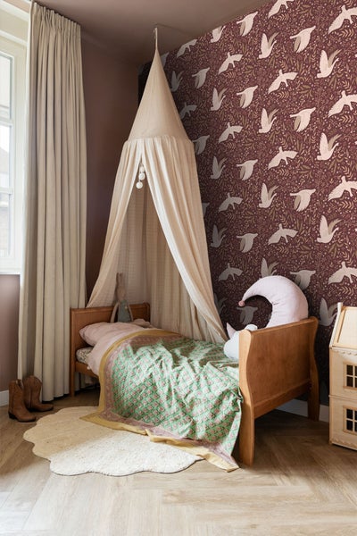 Kinderzimmer mit Bett, Baldachin und gemusterter Tapete