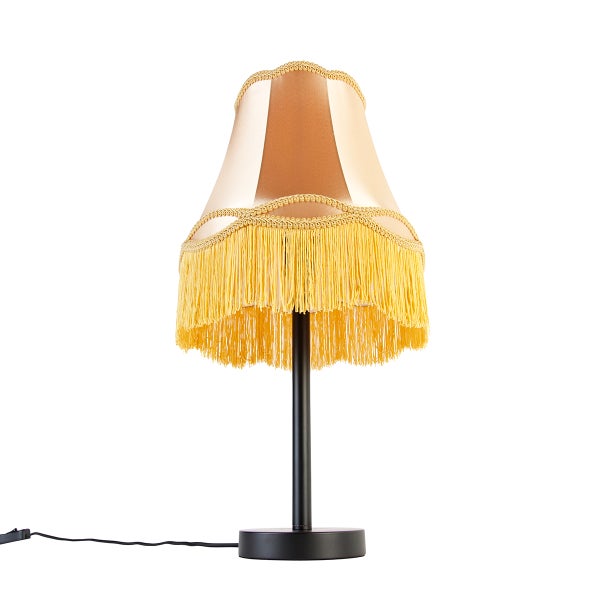 Vintage-Tischleuchte mit gelben Fransen, cremefarbenem Stoffschirm und schwarzem Metallfuß.