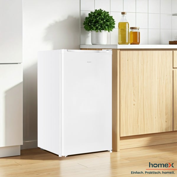 Kleiner weißer Kühlschrank in einer hellen Küche.
