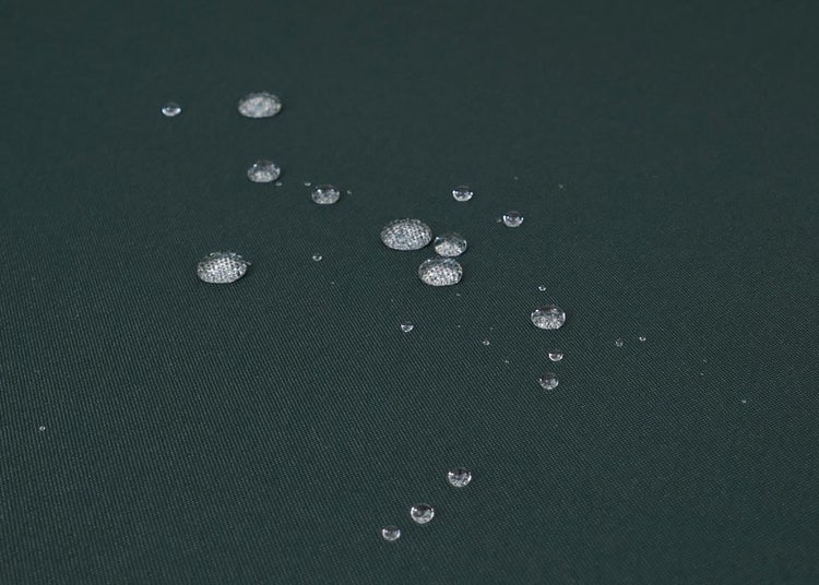 Wassertropfen auf der wasserabweisenden Oberfläche des Stoffes.