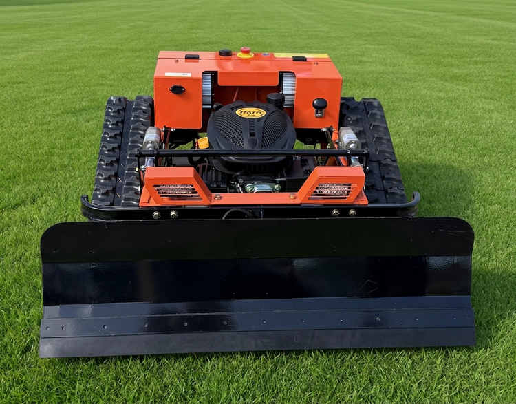 Ferngesteuerter Raupenmäher mit Schneeschild, orangefarbenes Gehäuse und schwarzer Rato Motor auf Rasenfläche.