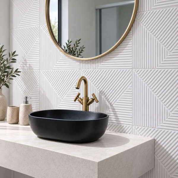 Modernes Badezimmer mit schwarzem Aufsatzwaschbecken, goldener Armatur, rundem Spiegel und strukturierten Fliesen auf der Waschtischplatte.