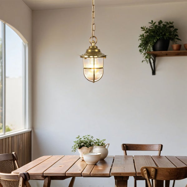 Esszimmer mit Holztisch, Stühlen und goldener Hängelampe