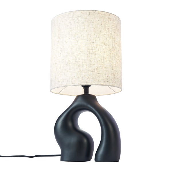 Moderne Tischleuchte mit abstrakt geformtem schwarzem Fuß und zylindrischem Textilschirm in Beige.