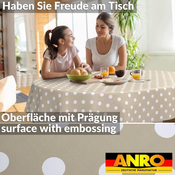 Runder Tisch mit gepunkteter Tischdecke und geprägter Oberfläche. Eine Frau und ein Kind frühstücken. ANRO DEUTSCHE MANUFAKTUR Logo.