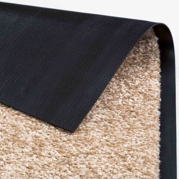 Detailansicht einer beigen Teppichmatte mit schwarzer Rückseite.