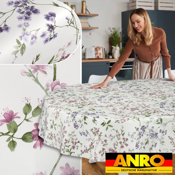 Runde Tischdecke mit feinem floralem Muster aus lila und rosa Blumen auf einem Tisch in einer hellen Küche, ANRO Logo.