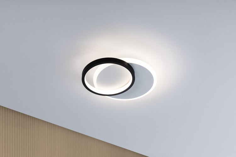 Moderne LED-Deckenleuchte mit zwei überlappenden Ringen in Schwarz und Weiß, installiert an einer hellen Decke.