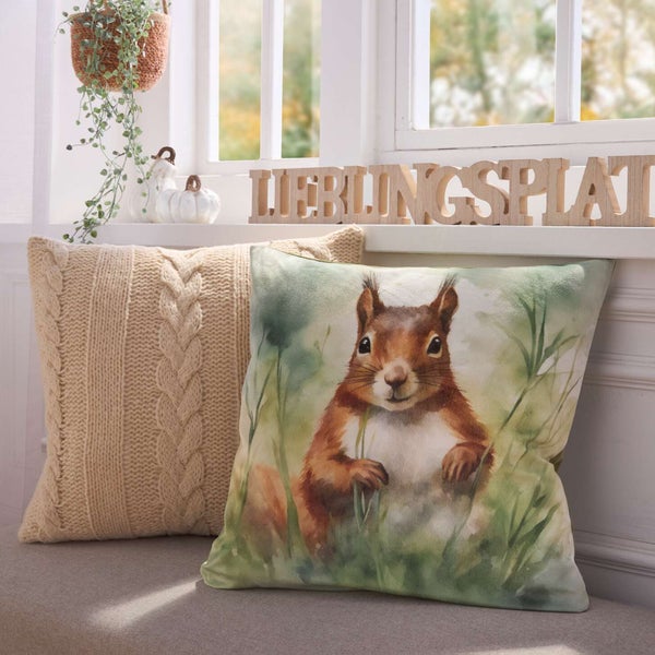 Dekorative Kissen mit Eichhörnchen- und Strickmuster auf einer Fensterbank