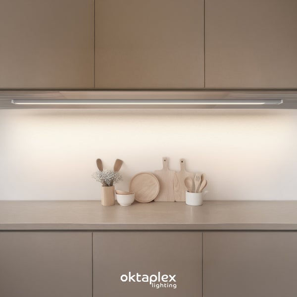 Oktaplex Lighting LED Unterbauleuchte in einer modernen Küche mit Küchenutensilien aus Holz auf der Arbeitsplatte.