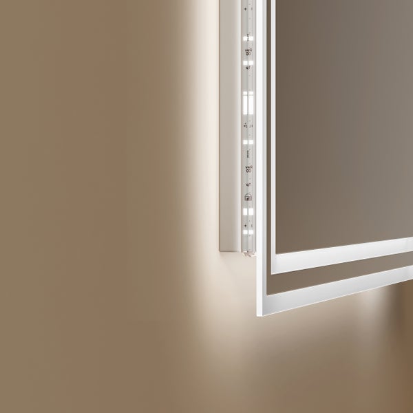 Detailansicht eines LED-Spiegels mit indirekter Beleuchtung an der Wand und sichtbarem LED-Streifen im Rahmen.