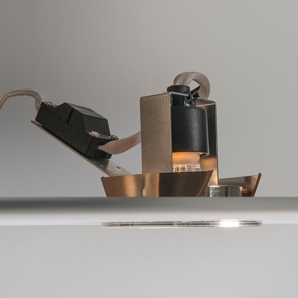 Einbaustrahler mit Metallgehäuse, Fassung und Anschlussbox in der Seitenansicht bei Deckenmontage.