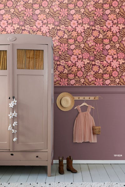 Kind vor einer Wand mit floraler Vliestapete und Wandpaneele im unteren Bereich.