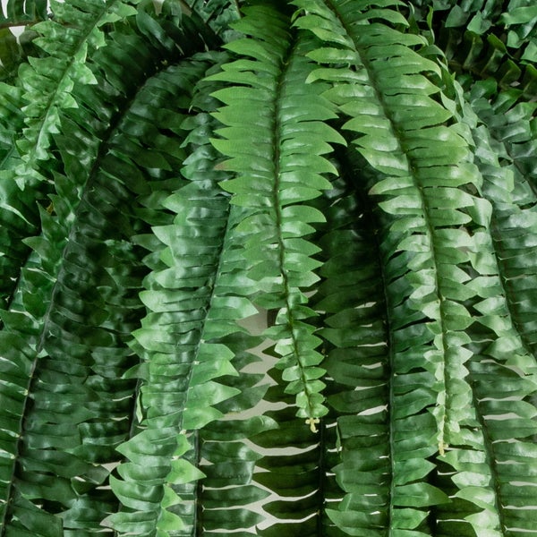 Künstliche Farnpflanze mit dichten grünen Wedeln aus Kunststoff.